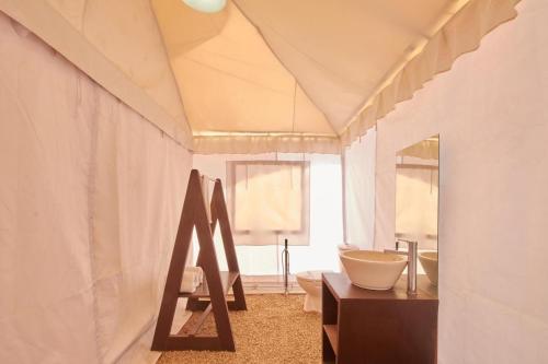 a bathroom with a sink and a toilet in a room at Savi Camps Jaisalmer in Sām