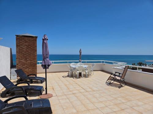 a balcony with a table and chairs and the ocean at acapulco 3 frontal in Oropesa del Mar