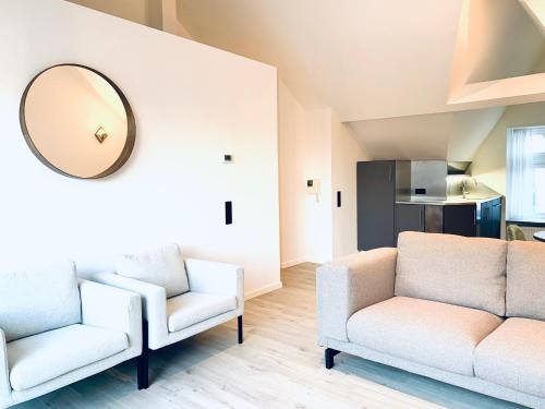 a living room with two chairs and a mirror at Belfort Shortstay in Ghent
