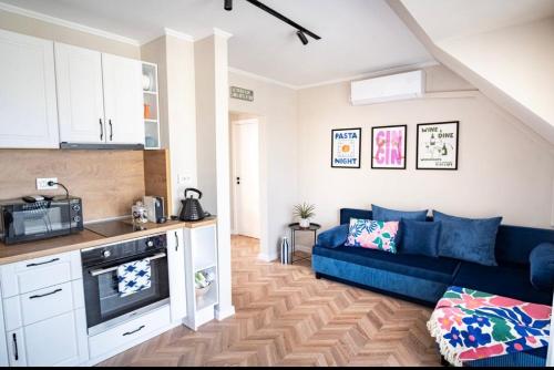 a kitchen and a living room with a blue couch at River View Ruse, Free Parking in Ruse