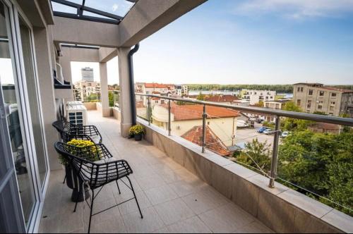 a balcony with chairs and a view of a city at River View Ruse, Free Parking in Ruse