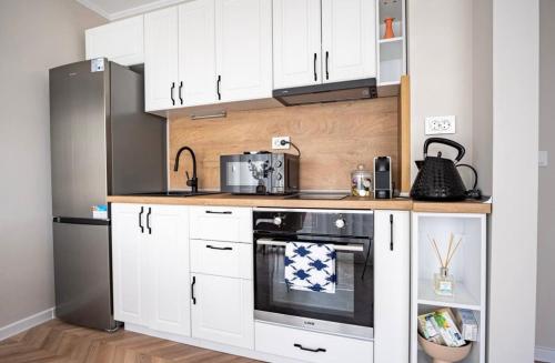 a kitchen with white cabinets and a stainless steel refrigerator at River View Ruse, Free Parking in Ruse