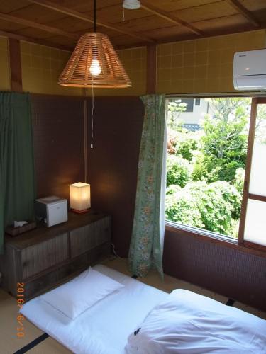 1 dormitorio con 2 camas y ventana en Thank you so muchya Eikando en Kyoto