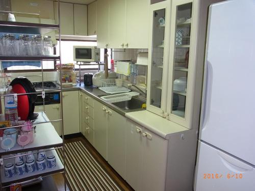 a kitchen with white cabinets and a white refrigerator at Thank you so muchya Eikando in Kyoto