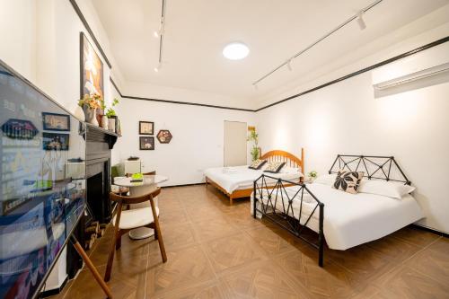 two beds in a room with a tv at Tonight Homestay West Nanjing Road Branch Shanghai in Shanghai