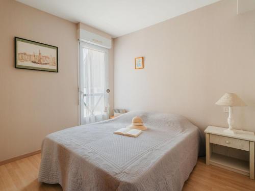 ein weißes Schlafzimmer mit einem Bett und einem Fenster in der Unterkunft Apartment Le Prince Noir by Interhome in Dinard