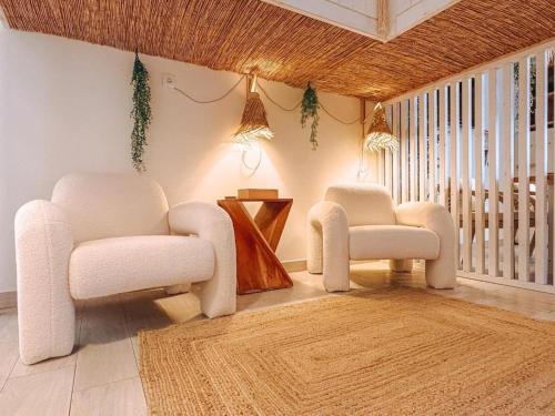 a living room with two chairs and a rug at Captain Cook AHOY in Praia da Areia Branca