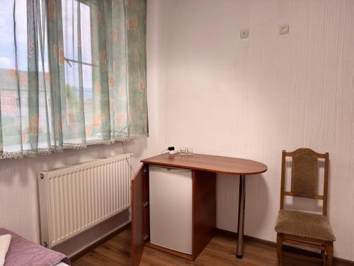 a table in a room with a chair and a window at Hotel Segafredo in Solotvyno