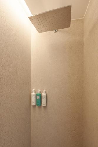 a bathroom with three shampoo bottles on a wall at Campoblù in Marina di Campo
