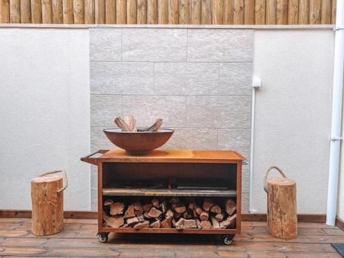 a bowl on top of a wooden cart with logs at Captain Cook AHOY in Praia da Areia Branca