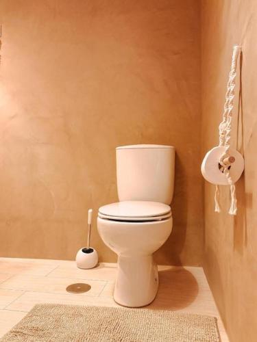 a bathroom with a white toilet in a room at Captain Cook AHOY in Praia da Areia Branca