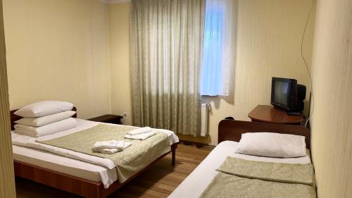 a hotel room with two beds and a television at Hotel Segafredo in Solotvyno