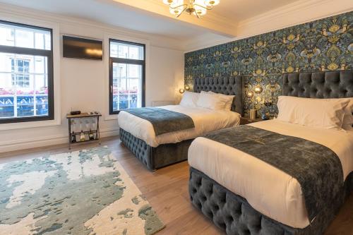 a hotel room with two beds and a large window at No 5 Rose Inn Street - Room 1 in Kilkenny