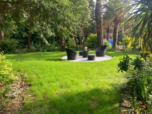a park with a row of benches in the grass at Appartement avec terrasse dans un parc privé in Bégard