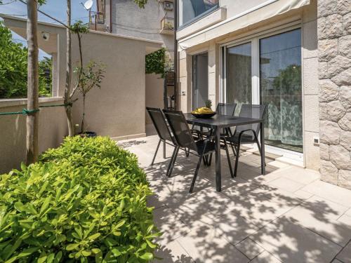 a black table and chairs sitting on a patio at Apartment Dita-1 by Interhome in Crikvenica