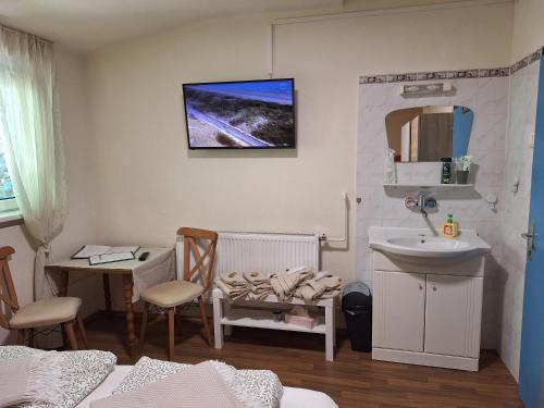 a bathroom with a sink and a table and a mirror at Haus Hoogendam in Leoben