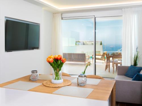 a living room with a table with flowers on it at Apartment D'Mediterranea private pool & sauna by Interhome in Torrox Costa
