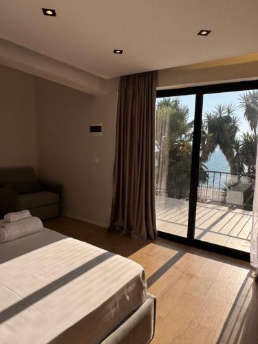 a bedroom with a bed and a large sliding glass door at Hotel Sanremo Vlore in Vlorë