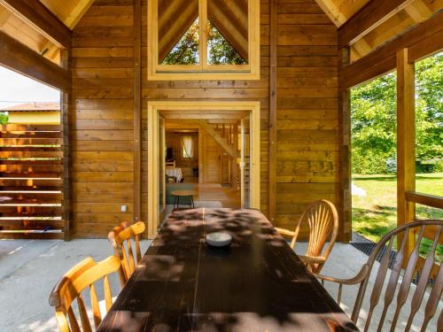 a wooden cabin with a long table and chairs at Chalet Jela by Interhome in Karlovac