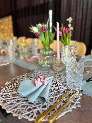a table with blue napkins and vases with flowers at Central Hotel Radviliškis in Radviliškis