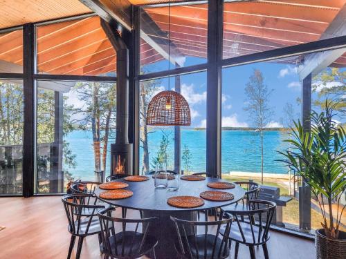 a dining room with a table and chairs and a view of the ocean at Holiday Home Villa haave by Interhome in Kustavi