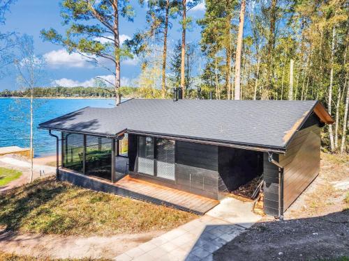 a small house with a deck next to a body of water at Holiday Home Villa haave by Interhome in Kustavi