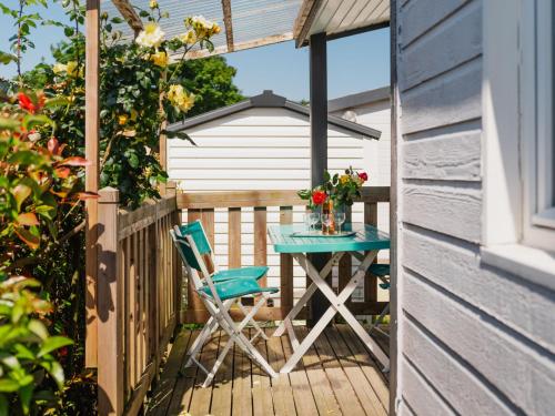 a table and a chair sitting on a deck at Chalet Le Bois d'Amour 2-2 by Interhome in Dinard