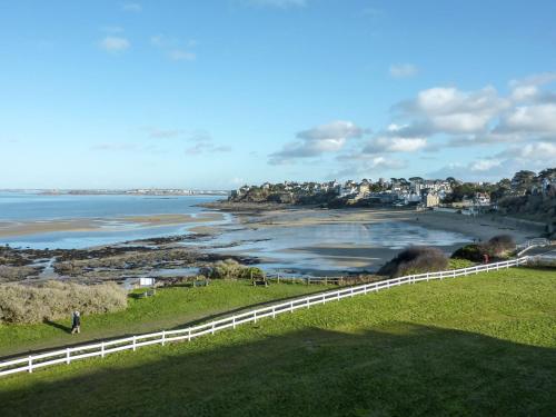 a view of a beach with a white fence at Chalet Le Bois d'Amour 2-2 by Interhome in Dinard