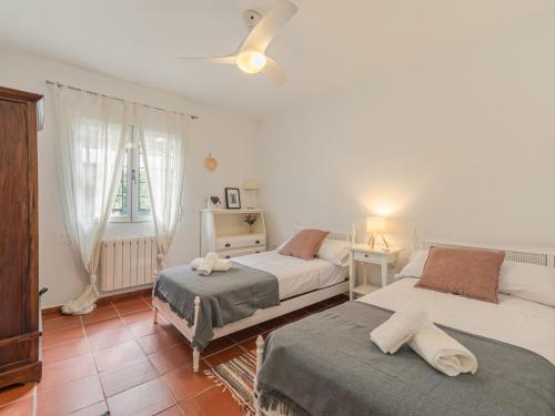 a bedroom with two beds and a ceiling fan at Villa Las Codornices-2 by Interhome in Sanlúcar la Mayor