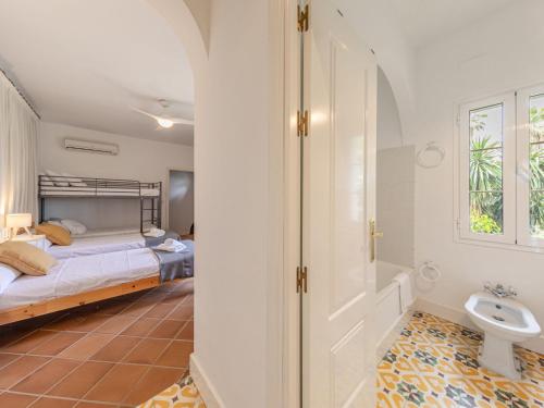 a bedroom with a bed and a sink and a toilet at Villa Las Codornices-2 by Interhome in Sanlúcar la Mayor