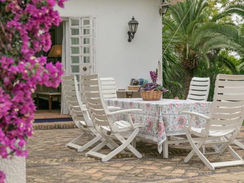a table and chairs on a patio with purple flowers at Villa Las Codornices-2 by Interhome in Sanlúcar la Mayor