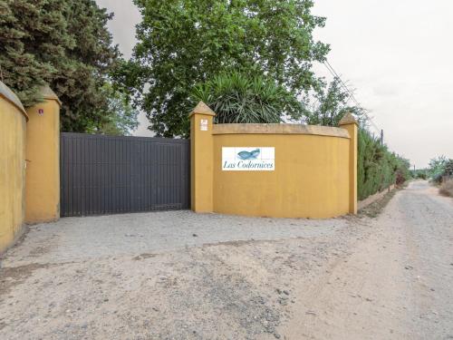 a yellow fence with a sign on it next to a dirt road at Villa Las Codornices-2 by Interhome in Sanlúcar la Mayor