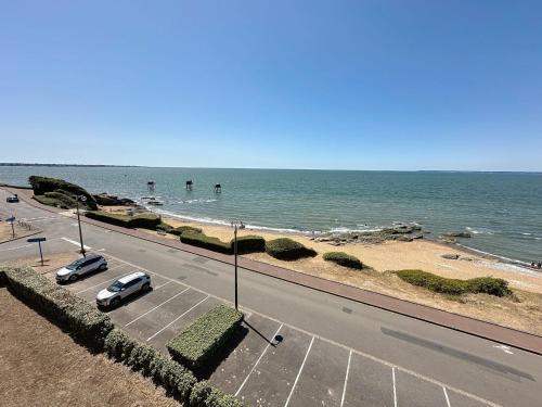 a road with two cars parked next to the beach at Apartment Le Sextant by Interhome in Saint-Michel-Chef-Chef
