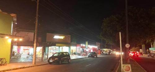 a city street at night with cars driving down the street at CASA - 2 minutos do aeroporto - 3 qtos com ar in Campo Grande