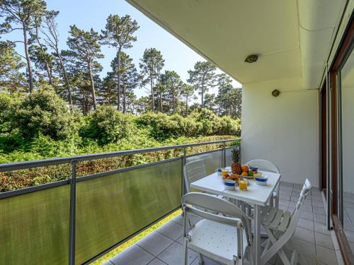 a balcony with a white table and chairs and trees at Apartment Men Er Bellec-4 by Interhome in Saint-Philibert