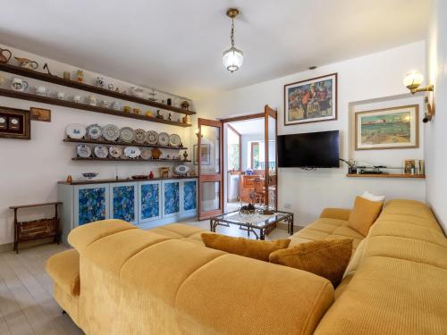 a living room with a couch and a tv at Holiday Home Lu Nibbaru di Portobello by Interhome in Aglientu