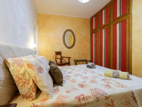 a bedroom with a bed and a mirror at Holiday Home Lu Nibbaru di Portobello by Interhome in Aglientu