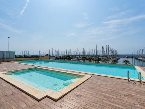 a large swimming pool with a view of a marina at Apartment Entre Bateau et Mer by Interhome in Santo Stefano al Mare