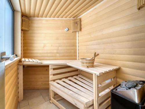 a wooden sauna with a bench and a basket at Apartment Dita-2 by Interhome in Crikvenica
