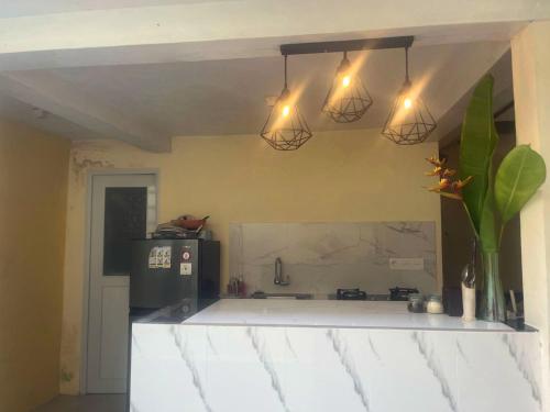 a kitchen with three lights hanging from the ceiling at Oemah Dharma Garden View by EPS in Gianyar