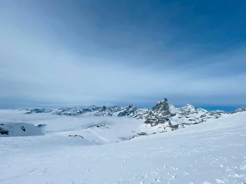a mountain covered in snow with the sky in the background at Casa Preziosa Cielo Alto in Breuil-Cervinia