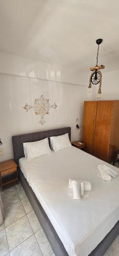 a bedroom with a large white bed with towels on it at Julsun apartment in Olympiaki Akti