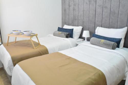 a hotel room with three beds and a table at Apartamento nuevo a 7 min de la Escuela de Cadetes in Bogotá