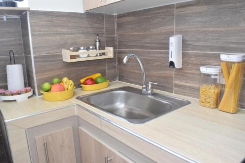 a kitchen with a sink and bowls of fruit at Apartamento nuevo a 7 min de la Escuela de Cadetes in Bogotá