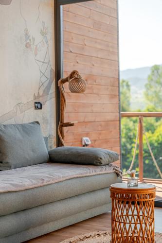 a couch in a room with a large window at Suspended Tiny House in Drumu Carului