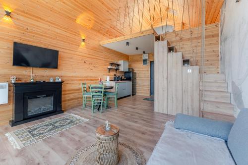 a living room with a fireplace and a kitchen at Suspended Tiny House in Drumu Carului