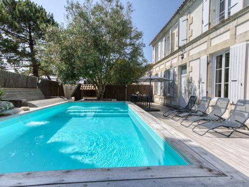 una piscina con sedie accanto a un edificio di Holiday Home Villa du Sourdonnet by Interhome a Les Mathes