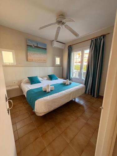 a bedroom with a bed with two stuffed animals on it at Siestamar II in Cala'n Porter