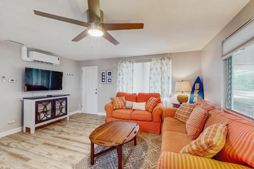 sala de estar con muebles de color naranja y TV de pantalla plana. en The Dockhouse, en Englewood