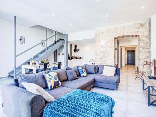 a living room with a couch and a staircase at Holiday Home La Grange by Interhome in Torreilles